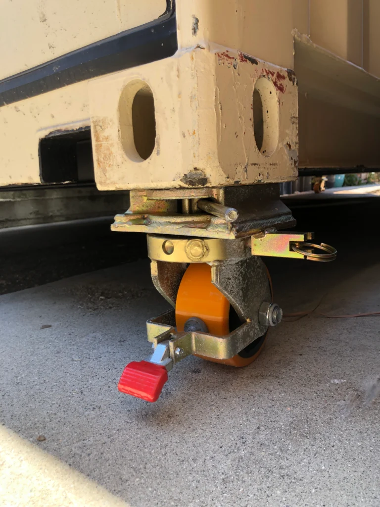 Twistlock Dynamics Compact casters supporting a shipping container on outdoor terrain.